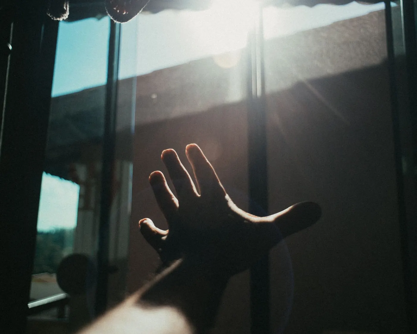 A hand reaching toward soft light A hand reaching toward soft light